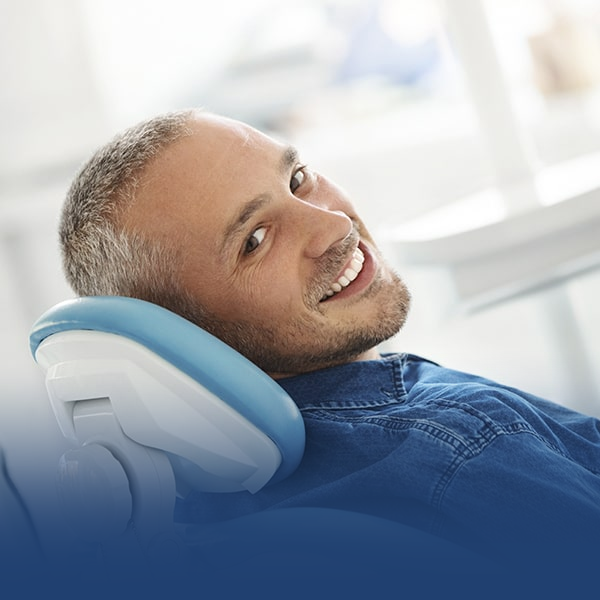 man smiling in a dentist's chair
